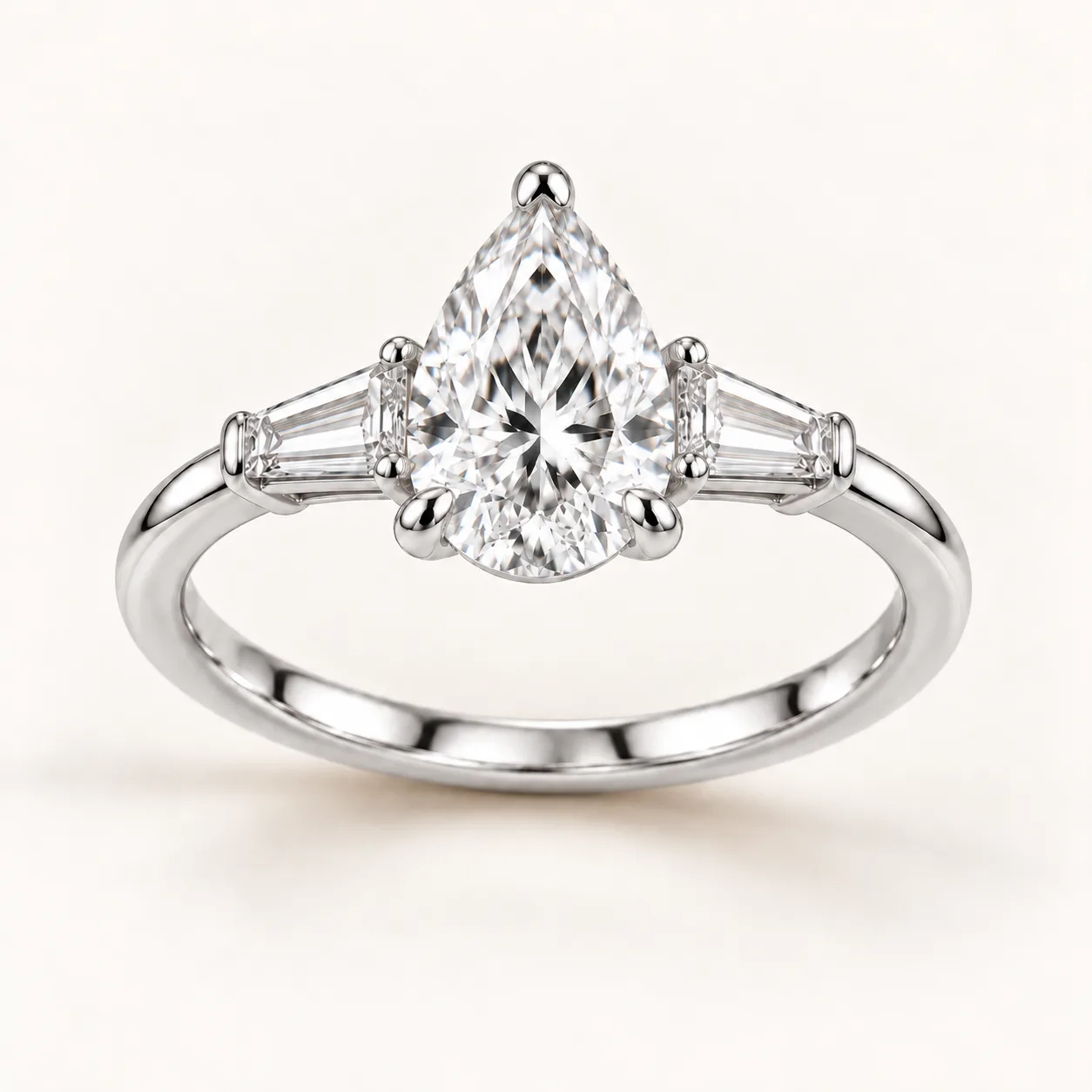 Pear diamond three-stone ring with tapered baguettes in white gold